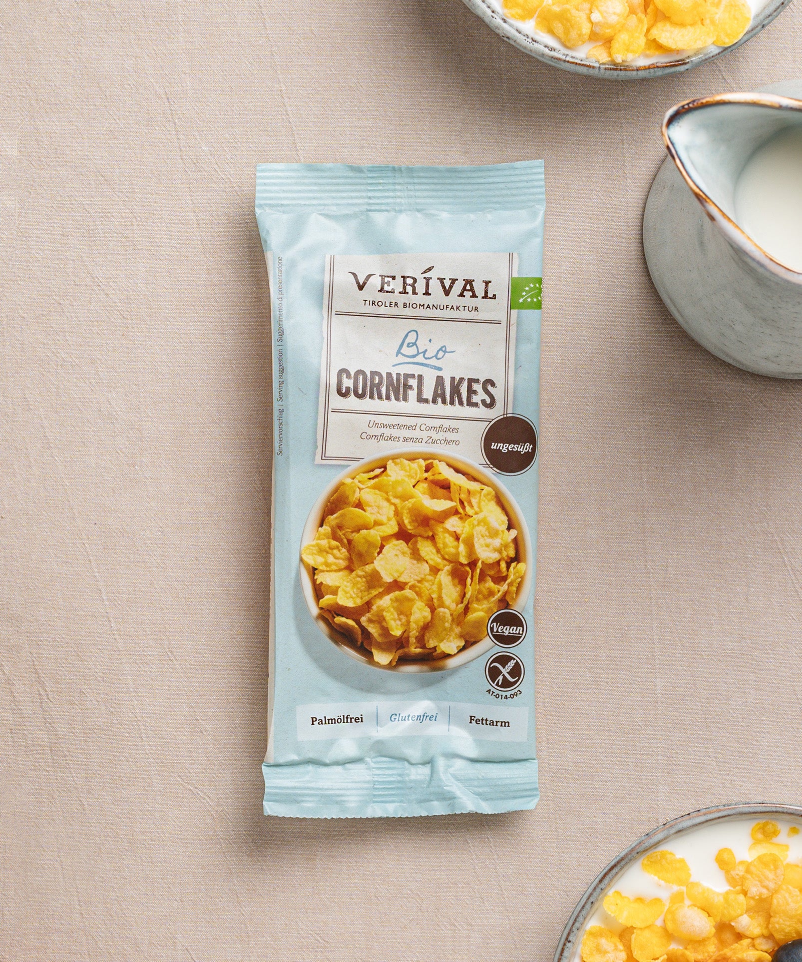 A Verival Bio GmbH Große Frühstücks-Probierbox Top 25 neben einer Schale Milch-perfekt für ein schnelles, abwechslungsreiches Bio-Frühstück.