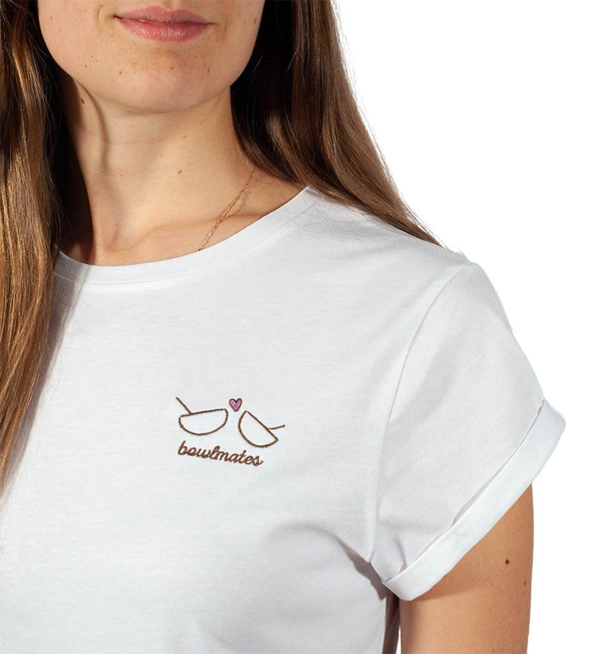 Eine Frau trägt das T-Shirt Bowlmates von Verival Bio aus nachhaltigem Bio-Baumwolle mit hochgekrempelten Ärmeln und einer Stickerei aus zwei Schüsseln, einem Herzen und dem Text „Bowlmates“. Ideal für FrühstücksliebhaberInnen, die Wert auf Stil und Umweltfreundlichkeit legen.